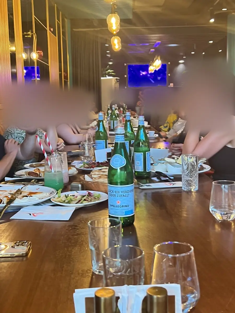 Gäste am Tisch, auf der San Pellegrino steht: Glück, ein Verdienst oder Zufall?